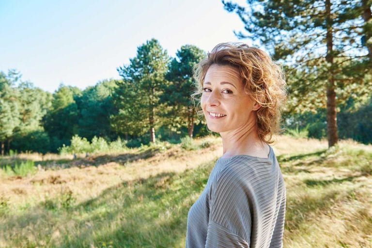 Smiling woman in the outdoors who has type 2 diabetes and is participating in a clinical research study.
